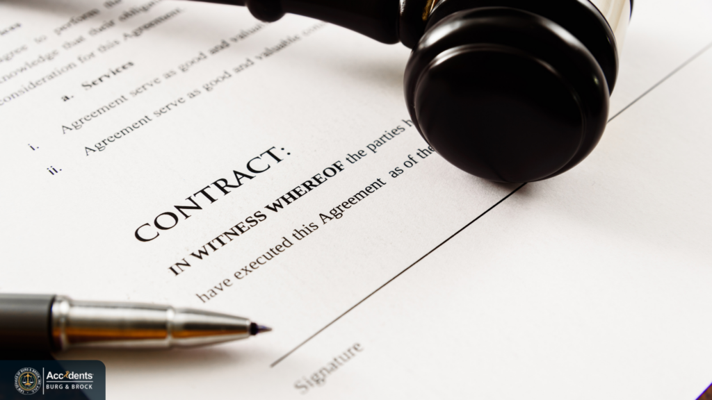 Close-up of a printed contract open at the signature line, with a judge's gavel resting on the page and a pen beside it